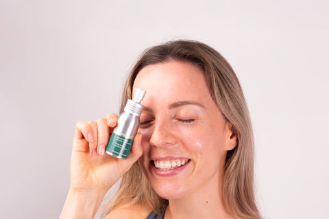 Jeune fille qui tient un flacon de sérum 