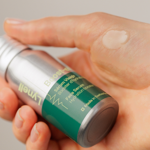Application du sérum visage Boost-ell de Lynell sur une main, texture hydratante visible.
